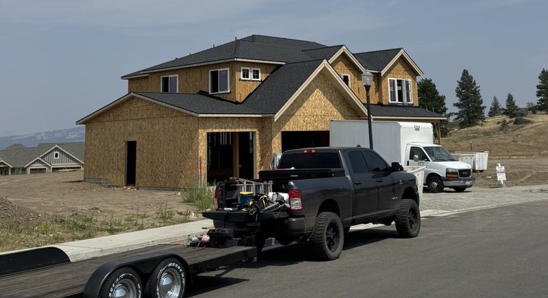 New construction two-story home with a finished architectural shingle roof, Fisk Industries truck and trailer parked out front