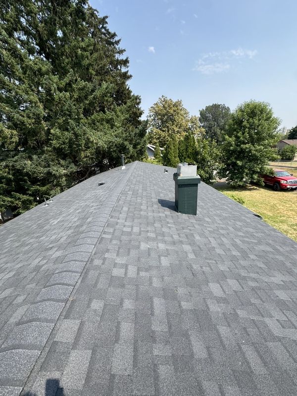 New construction two-story home with its black shingle roof completed during framing