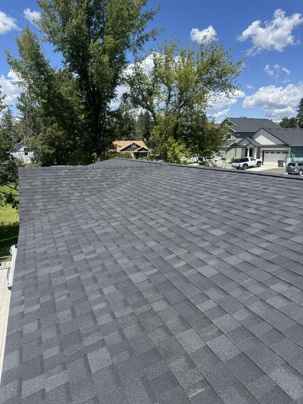 Long ridge line of a newly shingled roof in a rural neighborhood