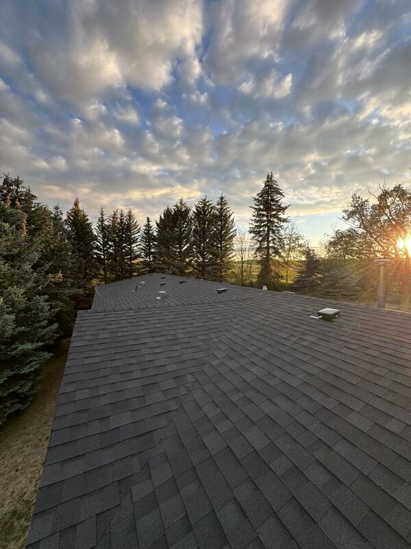 Completed roof at sunset with evergreen trees behind